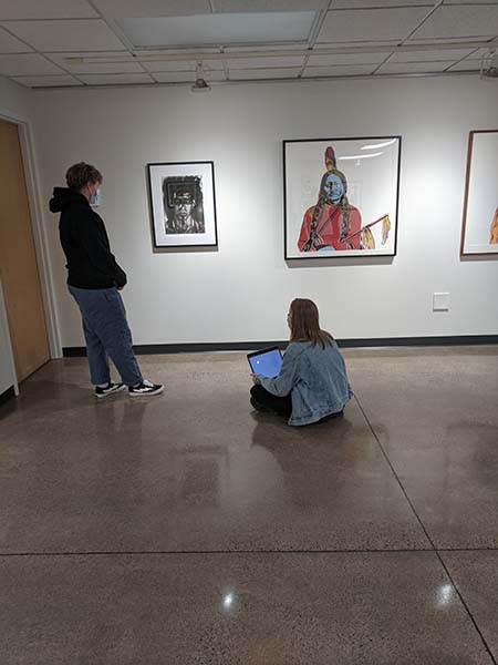 Two students looking at artwork at the museum