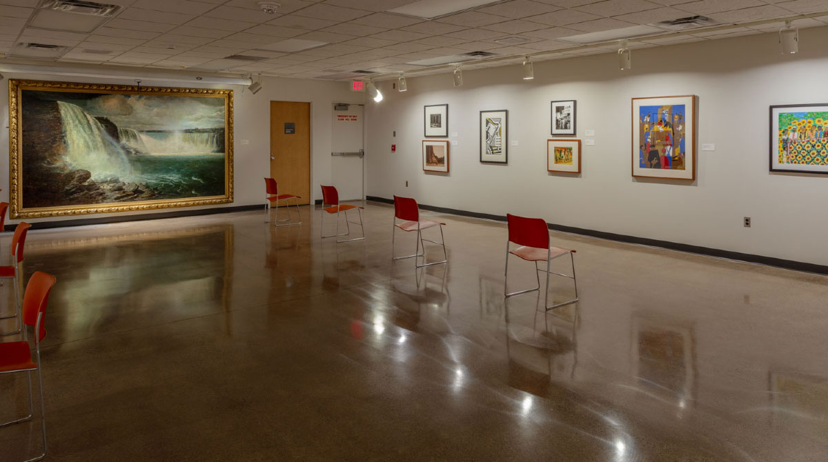 photograph of the tweed museum study room with four orange chairs and a large painting of niagara falls in the background by gilbert munger