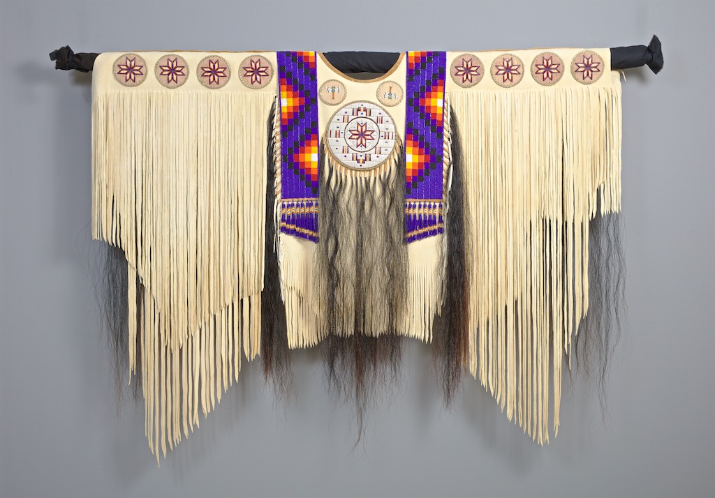  Native American war shirt, hide, beadwork, quillwork, birchbark, horsehair, and thread with purple, yellow, and red motifs