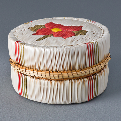 photo of a Native American round quilled box with red flower motif on the lid