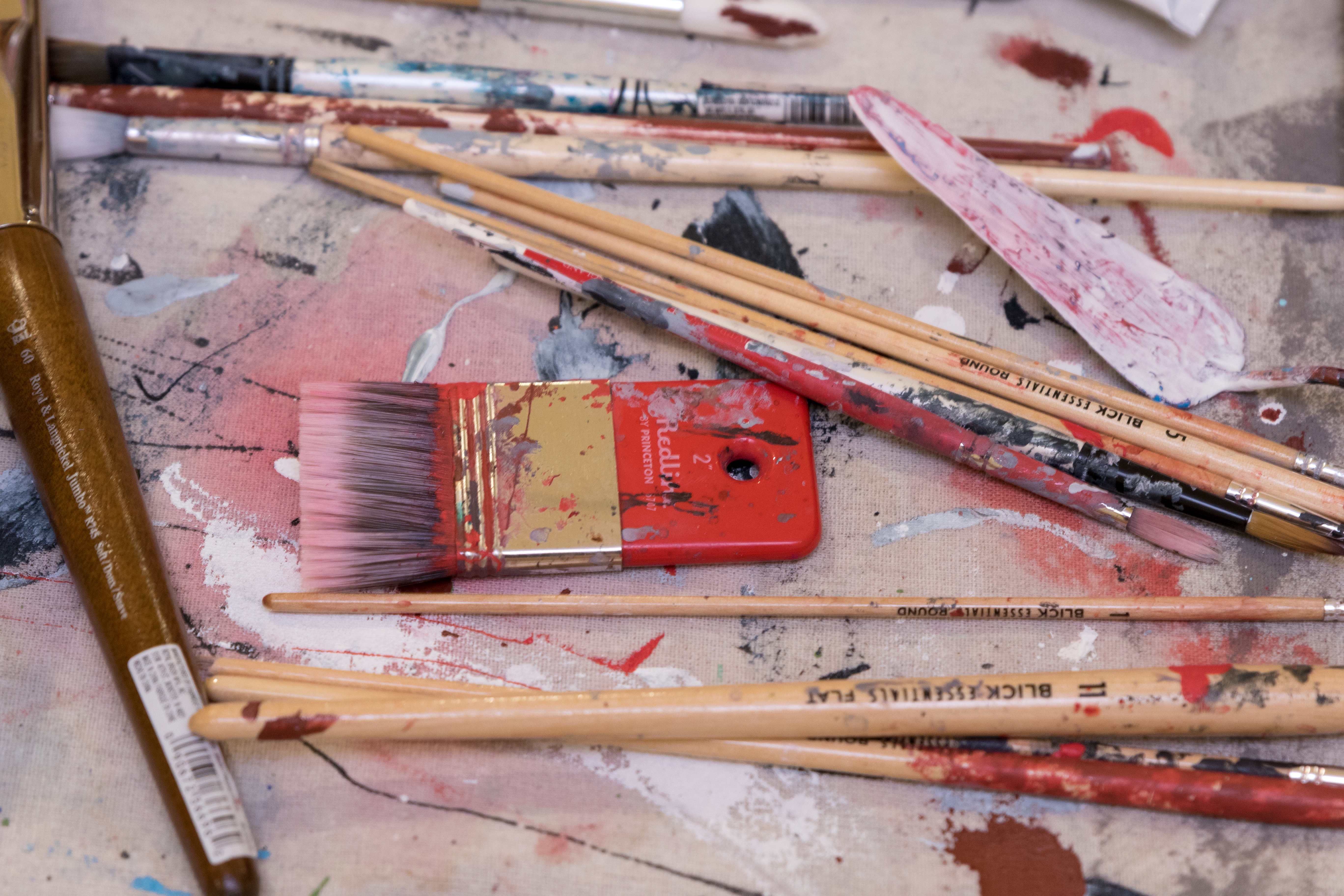 paint brushes scattered on a canvas
