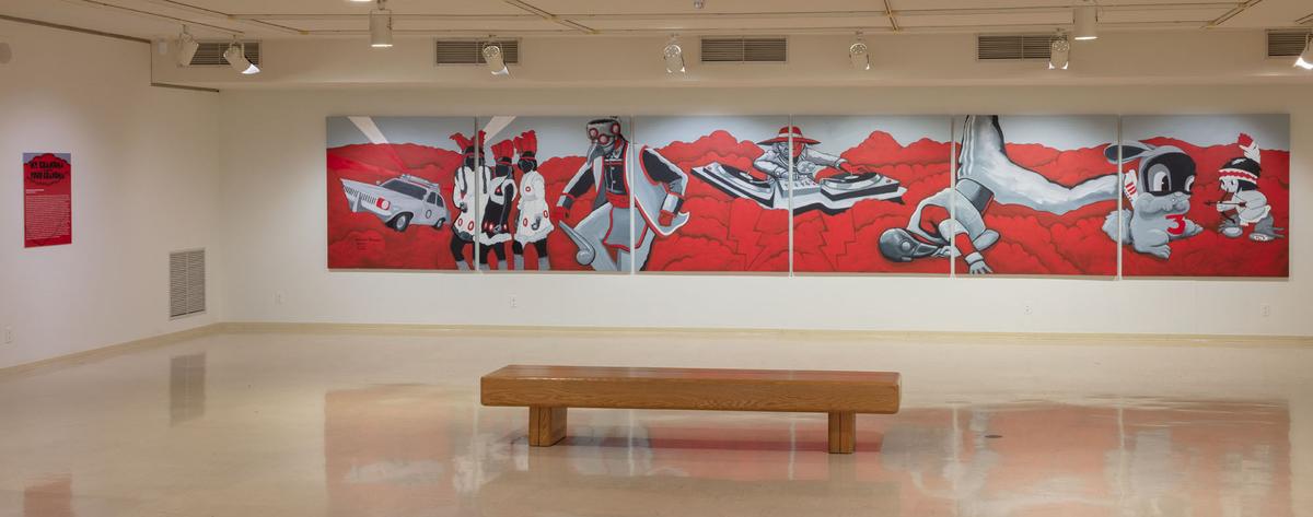 An art gallery with a large red and black mural on the wall.